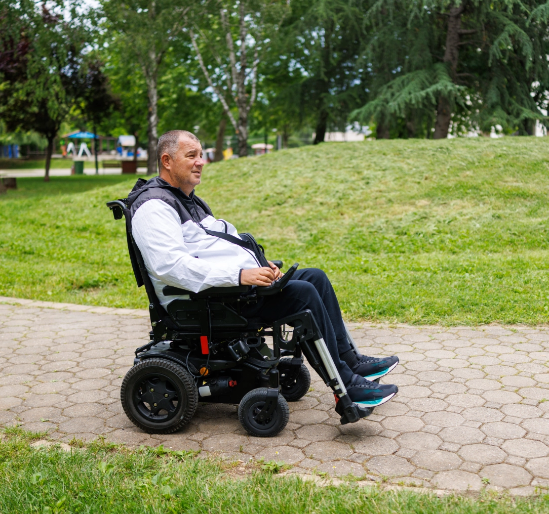 Man riding wheelchair on park path