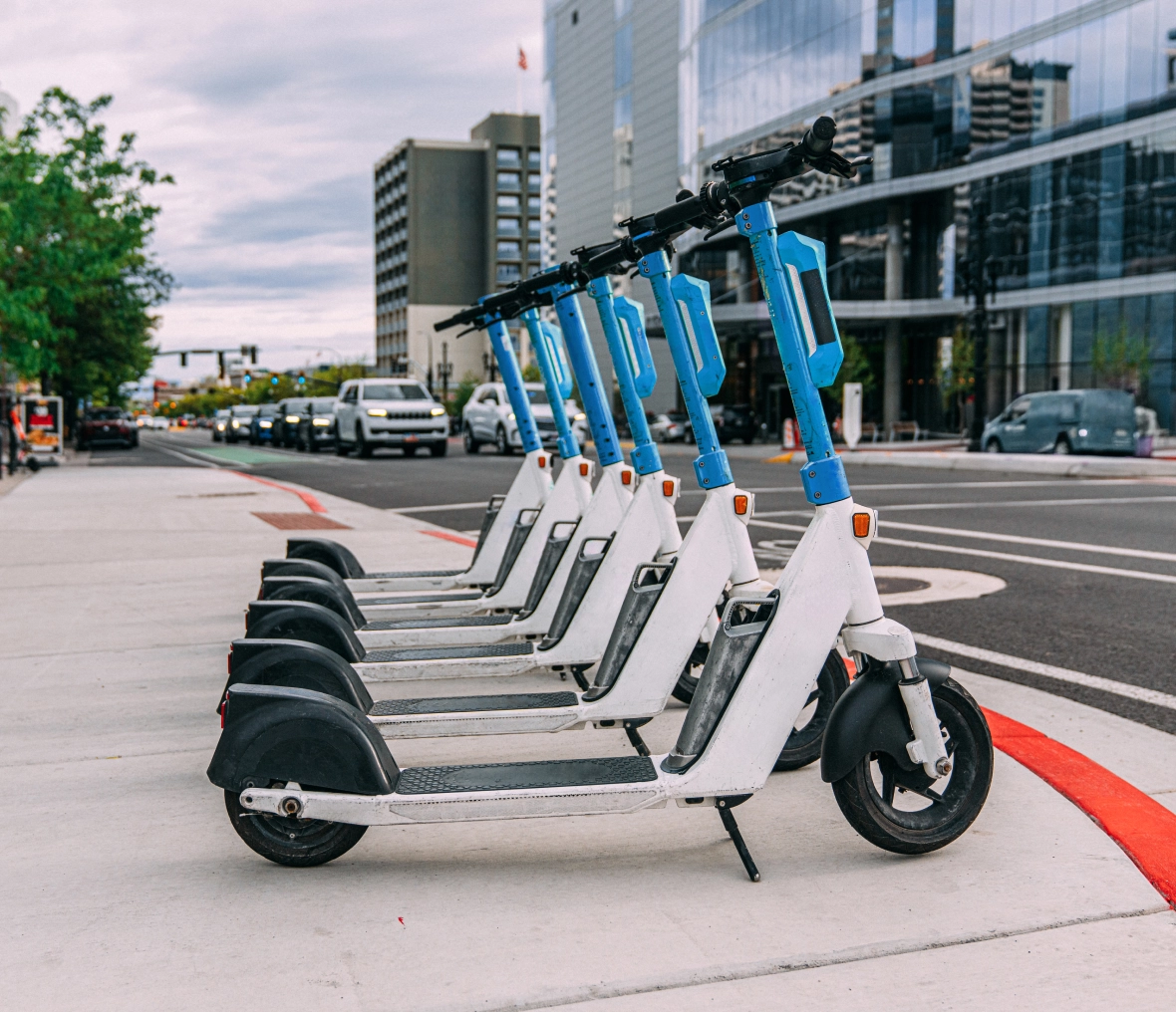 Electric scooters lined up on city sidewalk