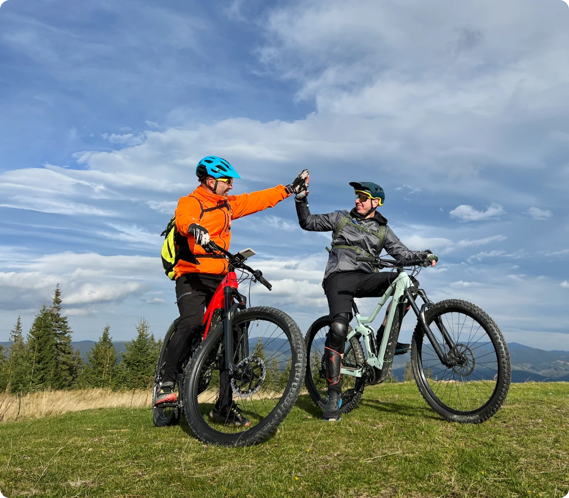 Two bikers celebrate on mountain trail